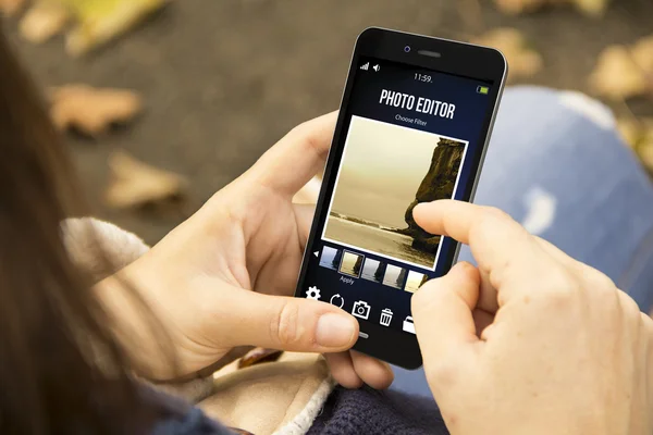 Vrouw met app van de redacteur van de foto in het park — Stockfoto