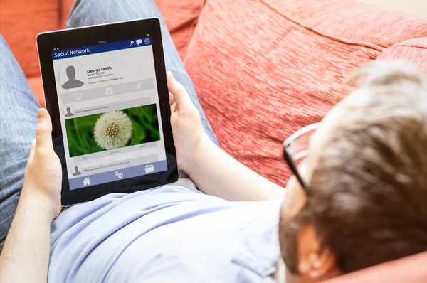 Homem com tablet no sofá — Fotografia de Stock