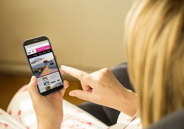 Mujer leyendo un blog de tendencias en smartphone —  Fotos de Stock