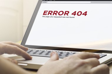 Hata 404 üstünde belgili tanımlık perde ile bir dizüstü bilgisayar kullanan adam