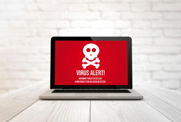 Bärbar dator med virus på en tabell — Stockfoto