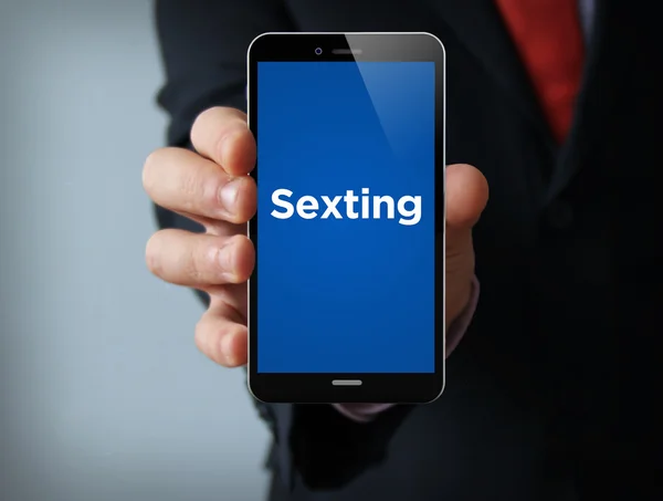 Hombre de negocios celebración de teléfonos inteligentes con aplicación de sexting —  Fotos de Stock