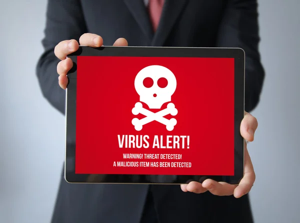Homme d'affaires avec alerte de virus sur une tablette — Photo
