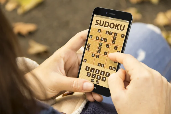 Frau spielt Sudoku-Spiel am Smartphone — Stockfoto