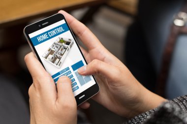 ev otomasyon uygulaması ile telefon kullanan kız