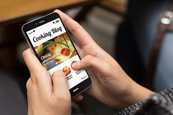 Ragazza utilizzando telefono con sito web blog di cucina — Foto Stock