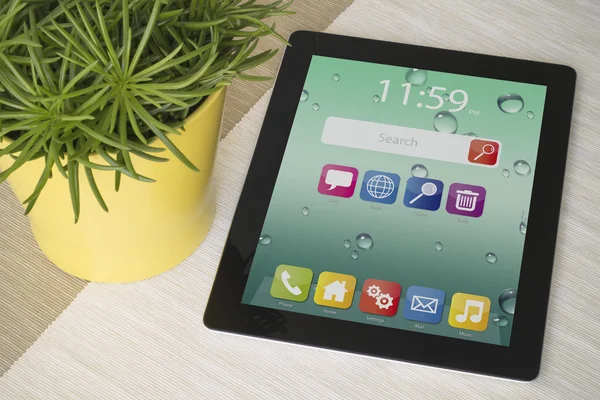 Tablet op tafel met plant — Stockfoto