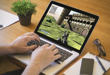 dizüstü bilgisayarda video oyunu oynayan adam