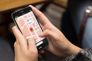 harita üstünde belgili tanımlık perde ile akıllı telefon kullanan kız