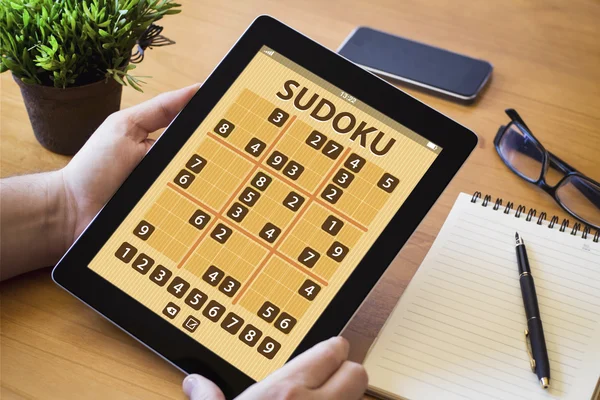 Άνθρωπος εκμετάλλευση δισκίο με sudoku — Φωτογραφία Αρχείου