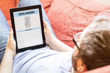 tablet ekranında diş sigortası ile olan adam