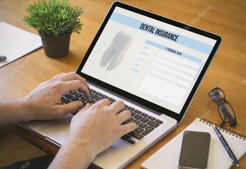 man working on laptop with dental insurance