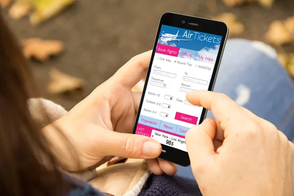 Kvinna med biljetter flyg programmet på telefon — Stockfoto
