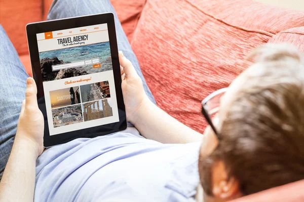 Man with tablet with travel agency website — Stock Photo, Image