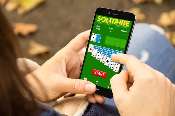 Vrouw met solitaire app op de telefoon — Stockfoto