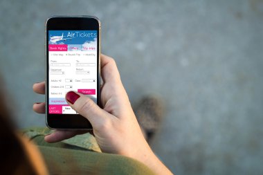 Woman walking with smartphone booking air tickets