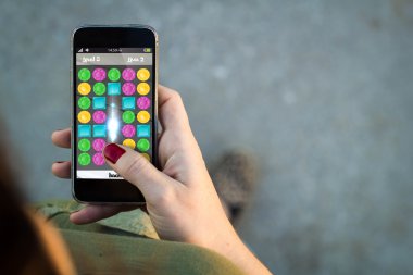 Woman walking with smartphone playing game