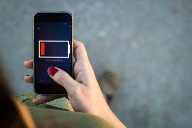 Woman walking with smartphone low battery