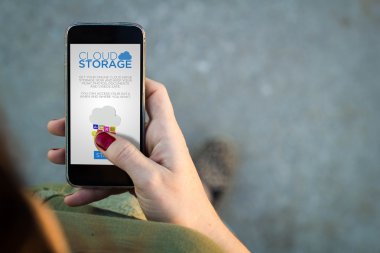 Woman walking with smartphone using cloud storage