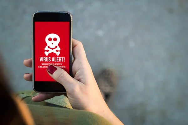 Woman walking with smartphone virus alert — Stockfoto