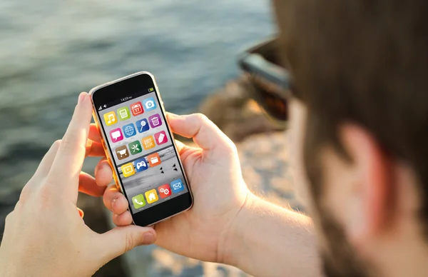 Mann benutzt sein Smartphone an der Küste — Stockfoto