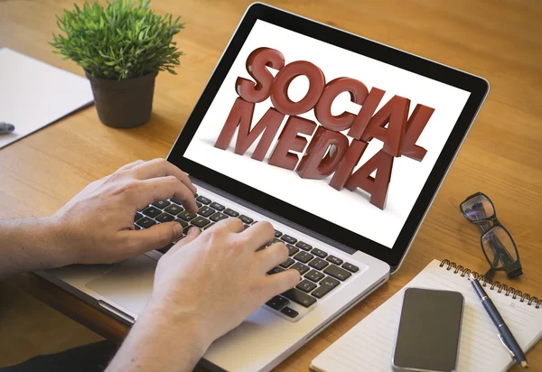 Man working on laptop using social media — Stock Photo, Image