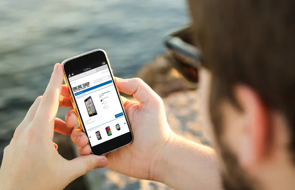 Man with smartphone at coast — Stock Photo, Image