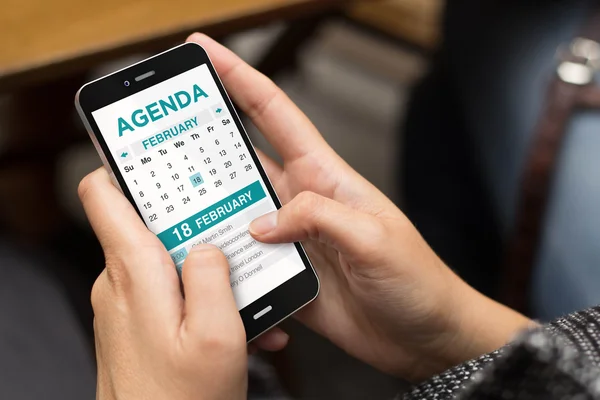 Meisje met telefoon met agenda op scherm — Stockfoto