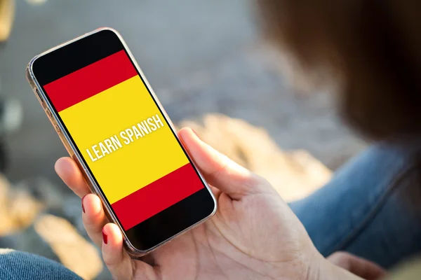 Woman sitting in the street holding her smartphone and learning — Stock Photo, Image