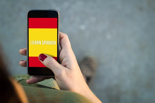 Woman walking with smartphone learn spanish interface — Stock Photo, Image