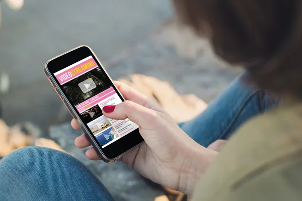 Woman touch the screen of her smartphone to watch movies — Φωτογραφία Αρχείου