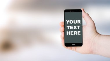 mobile phone with your text here on user hand