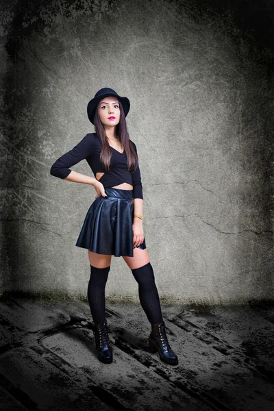 Deri ve şapka giymiş genç seksi kadın