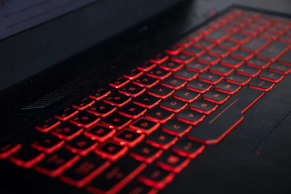 非常にエグゼクティブでプロフェッショナルなビジネスノートパソコンの背景に赤いライトが付いている黒いキーボード ストック写真