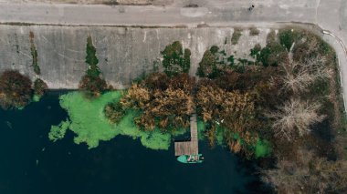Güzel nehrin havadan görünüşü ve yeşil çimlerde eski bir kayık.