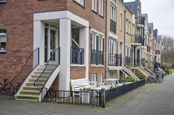 Voorschoten, The Netherlands, January 3, 2021: row of townhouses in Krimwijk neighbourhood with brick facades in a post-modern style with jugenstil influences