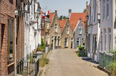 Zwartewaal, The Netherlands, June 12, 2021: traditional houses with brick and plaster facades in the village's main street on a sunny day