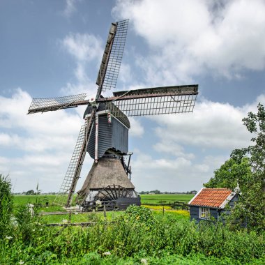 Streefkerk, Hollanda, 18 Temmuz 2021: 16. yüzyıl Broekmolen manzarası dost bulutlarla dolu bir yaz gökyüzüne karşı