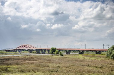 Zwolle, Hollanda, 4 Ağustos 2021 IJssel nehri, sel yatakları ve Hanzeboog demiryolu köprüsü üzerindeki dramatik bulutlar
