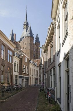 Zwolle, Hollanda, 9 Ağustos 2021, Sassenpoort Kulesi 'nin tuğla ve alçı cephesinin üzerinden yükselen dar sokak