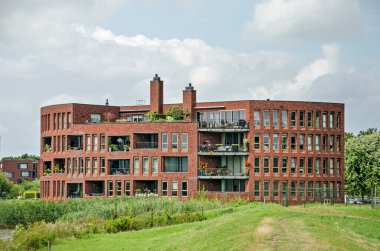 Zwolle, Hollanda, 4 Ağustos 2021: kırmızı tuğla cepheli ve yeşil ortamda dairesel bir zemin planı olan bir yerleşim yeri.