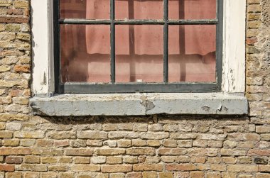 Eski ve sert tuğla dış görünüşlü, penceresi harap.