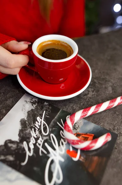 Masanın üzerinde kırmızı bir fincan kahve var.