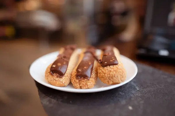 Geleneksel Fransız tatlısı. Beyaz tabakta çikolata kremalı ekler.