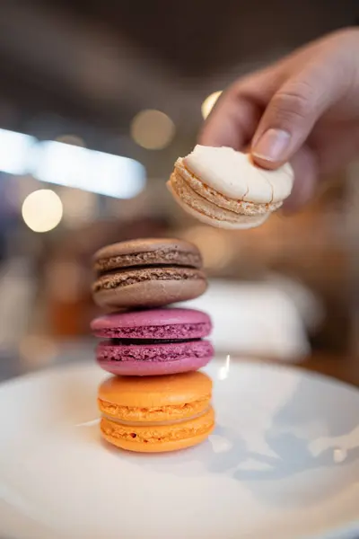    Beyaz bir tabakta renkli makaronlar.