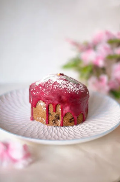 Beyaz tabakta pembe kremalı paskalya pastası.