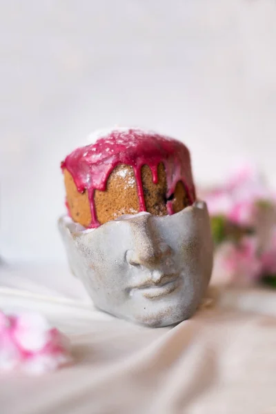 Jöleli Paskalya pastası pudra şekeriyle süslenir. Tahtada ve yeşil havluda. Mutlu Paskalyalar. Parçalara ayrılmış. Meyveleri salkım salkım.