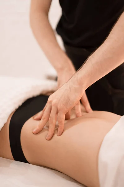 Bir adam bir kıza masaj yapar.