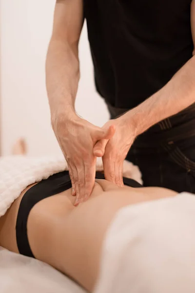 Bir adam bir kıza masaj yapar.