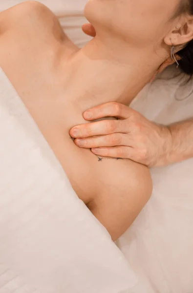 Bir adam bir kıza sırt masajı yapıyor.